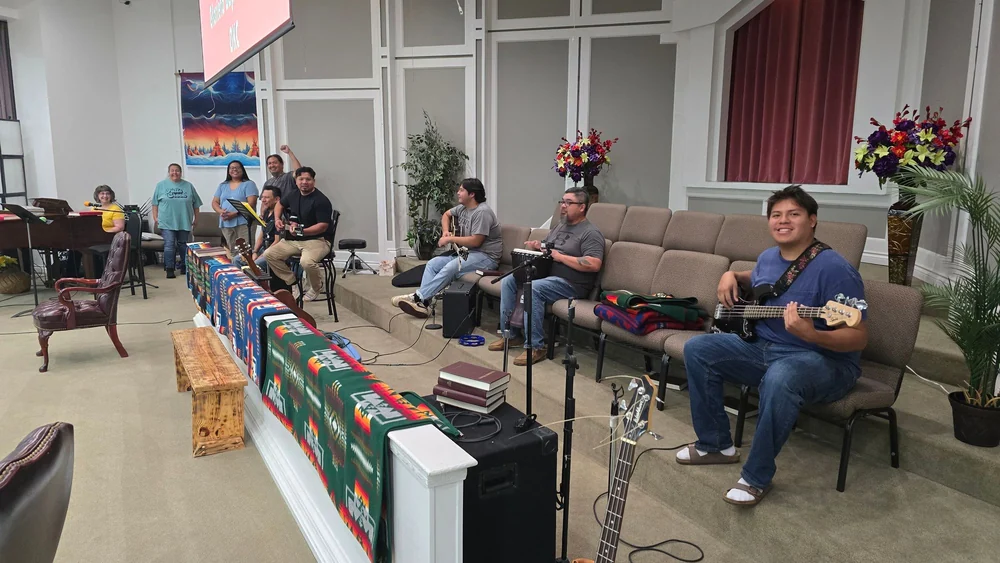 Glorieta musicians and singers gathered in their sanctuary with guitars and a piano.